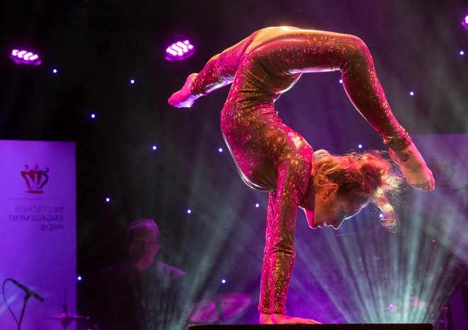 Eine Akrobatin führt eine Kunststück auf der Bühne auf.