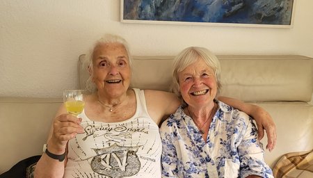 Eine Ehrenamtliche (re.) und "ihre" ältere Dame (li.) verbringen einen fröhlichen Nachmittag