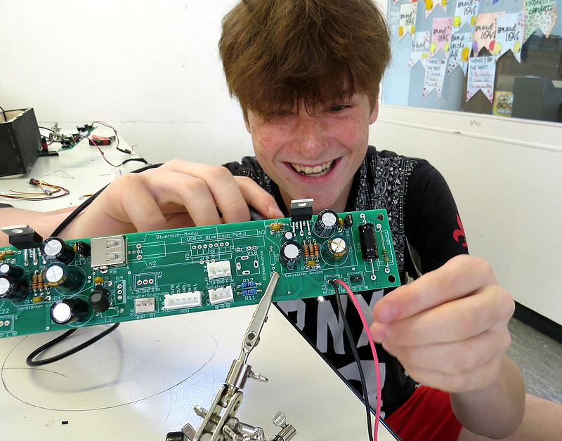 Ein Teilnehmer beim Bestücken und verlöten von Bauteilen auf einer Leiterplatte