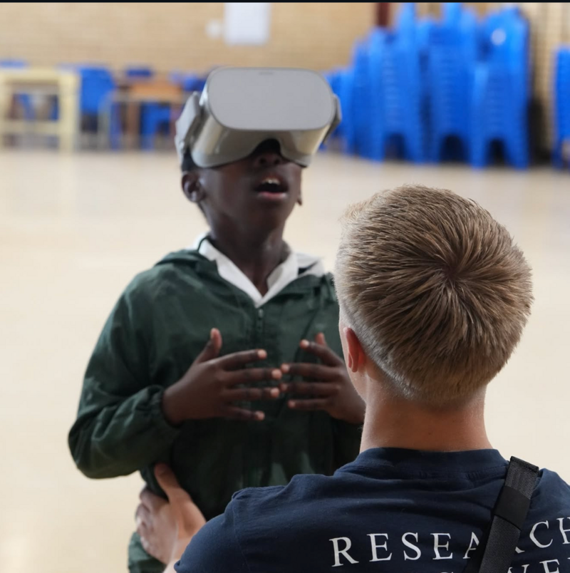Paul Zemke setzt einem Schulkind eine VR-Brille auf, mit der es zum ersten Mal die Unterwasserwelt erlebt