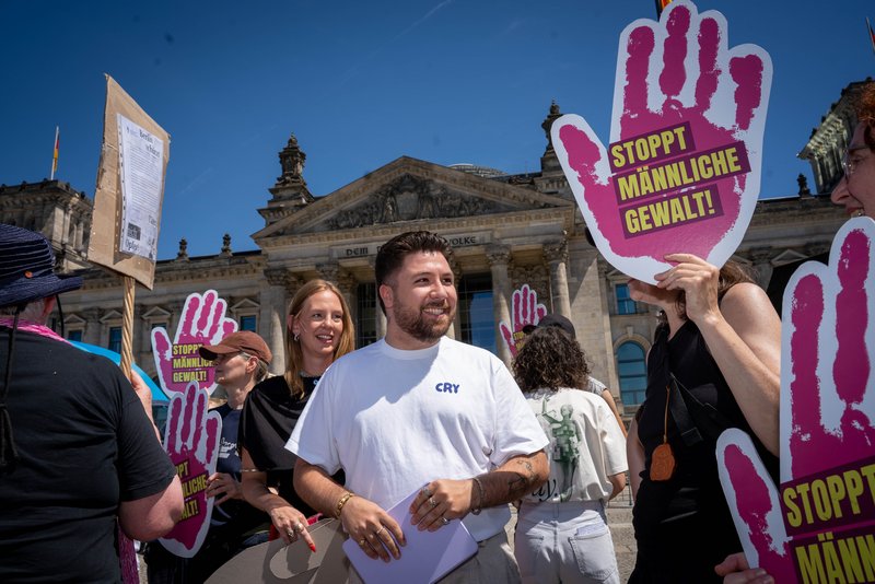 Battal zentral, drumherum Menschen, die Schilder mit "Stoppt männliche Gewalt!" hochhalten