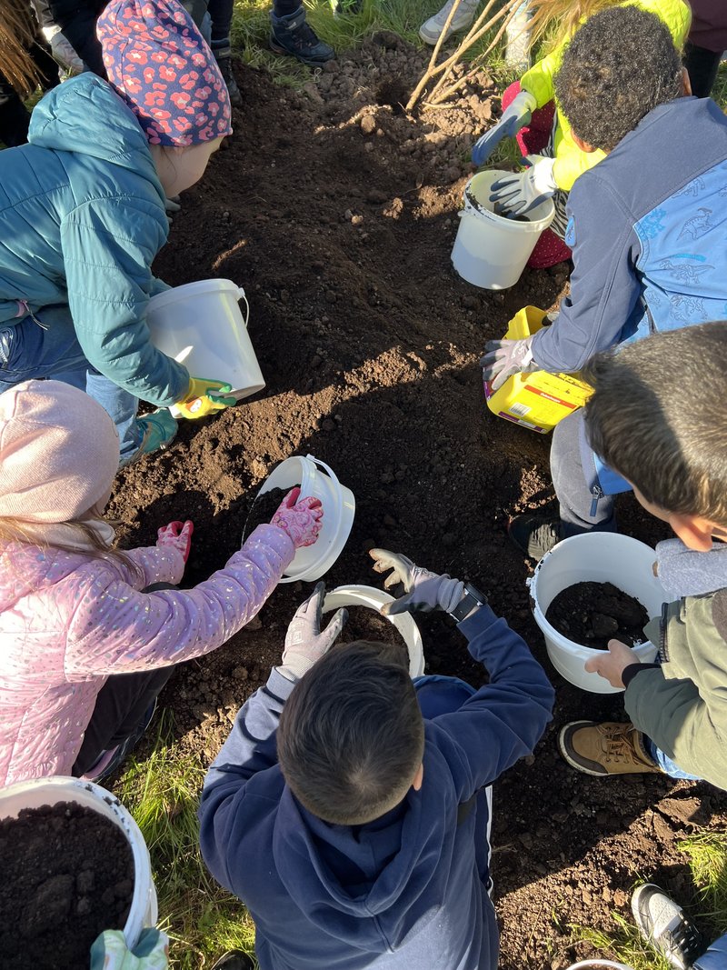 Kinder mit Eimer mit Erde am Gärtnern