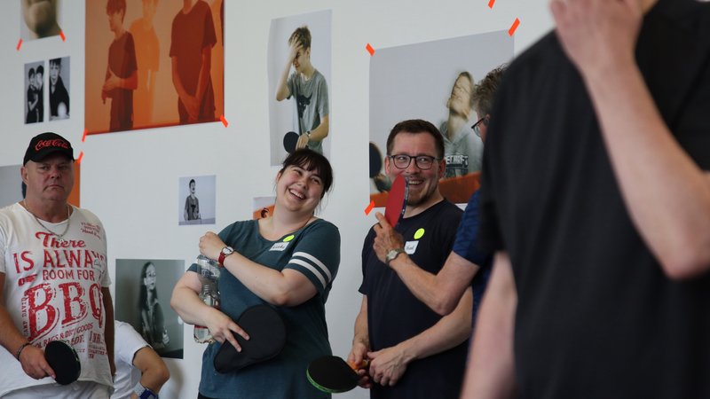 Lachende Menschen beim Tischtennisspielen