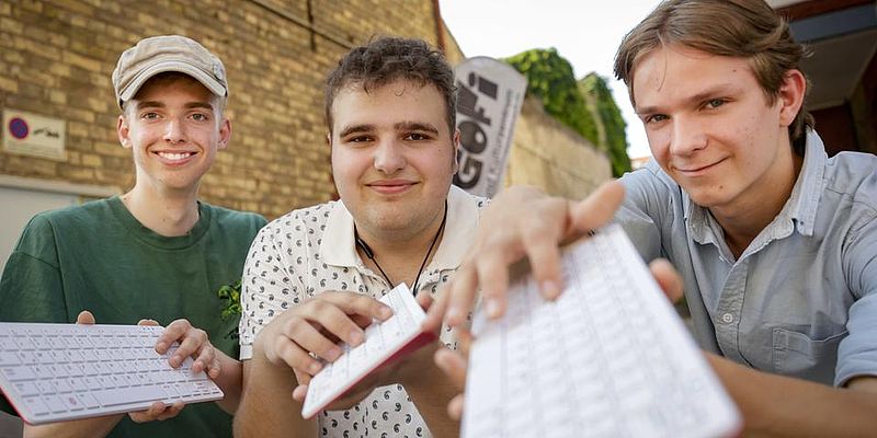 Menschen schauen mit Tastatur in die Kamera