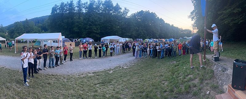 Kinder schauen zu wie die Fahne gehisst wird.
