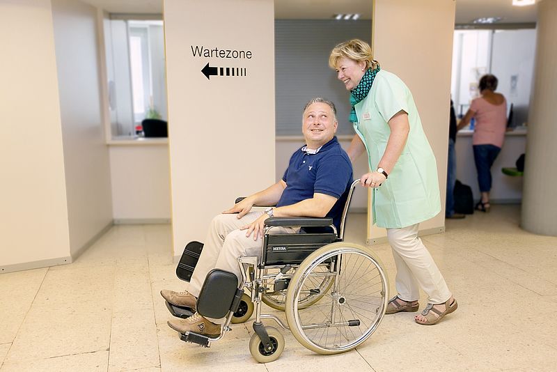 Grüne Dame im Krankenhaus unterstützt Patienten auf dem Weg zur 