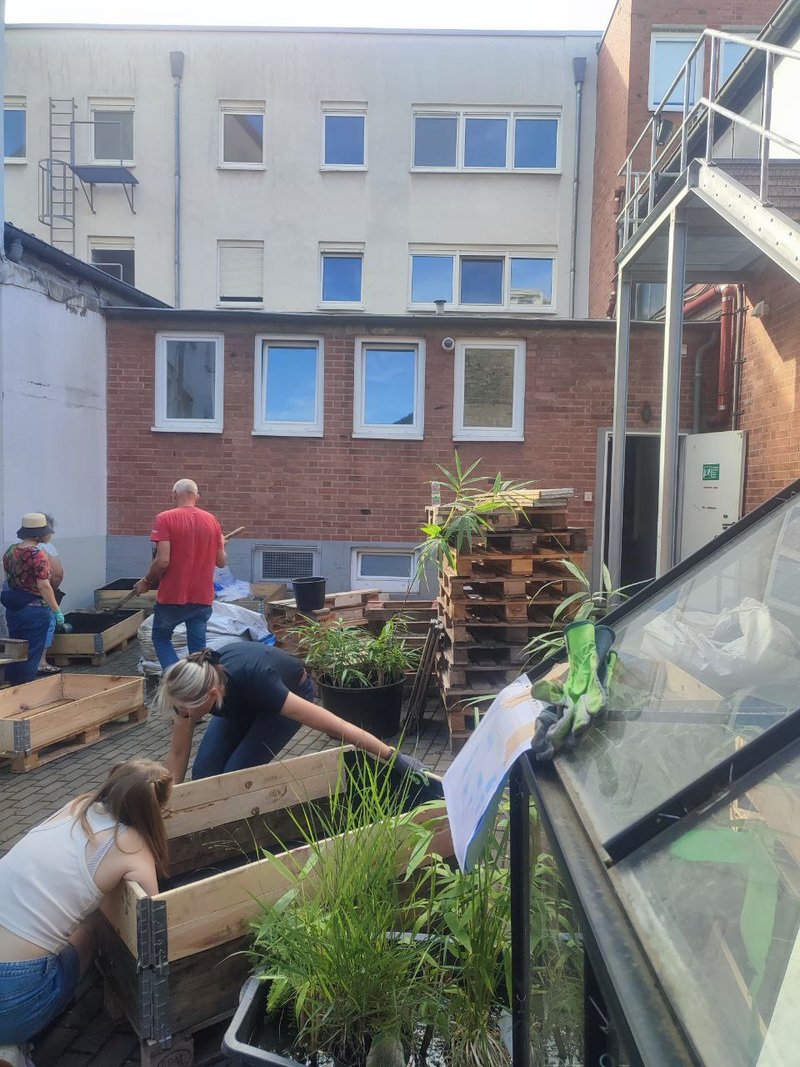 Vereinsmitglieder kleiden die Palettenbeete aus