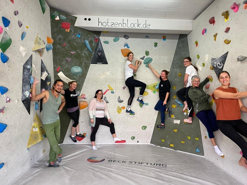 Eine Gruppe von Erwachsenen aus dem Landfrauentreff posiert gemeinsam an der Boulderwand im HotzenBlock.