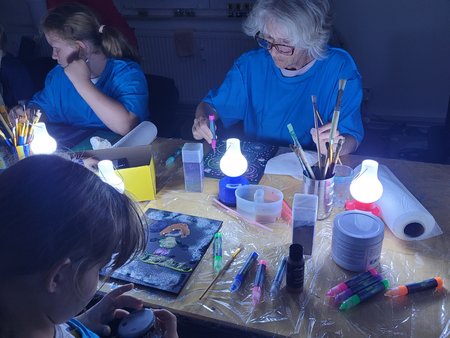 Betreute Kinder malen gemeinsam mit Ehrenamtlichen