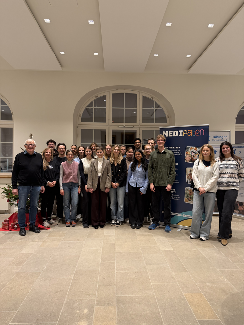 Gruppenfoto anlässlich der offiziellen Vereinsgründung des MEDI Paten e. V. in Tübingen. Mitglieder und Unterstützer:innen stehen gemeinsam in einem hellen Veranstaltungsraum vor einem MEDI-Paten-Aufsteller. Das Bild dokumentiert die Gründung des studentisch getragenen Vereins, der sich für schwer und chronisch erkrankte Kinder und Jugendliche engagiert.
