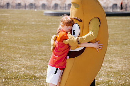 Ein BFL Profi umarmt unser Maskottchen