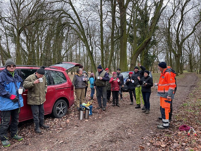 Drei junge Menschen stehen an einem Tresen und lächeln in die Kamera.