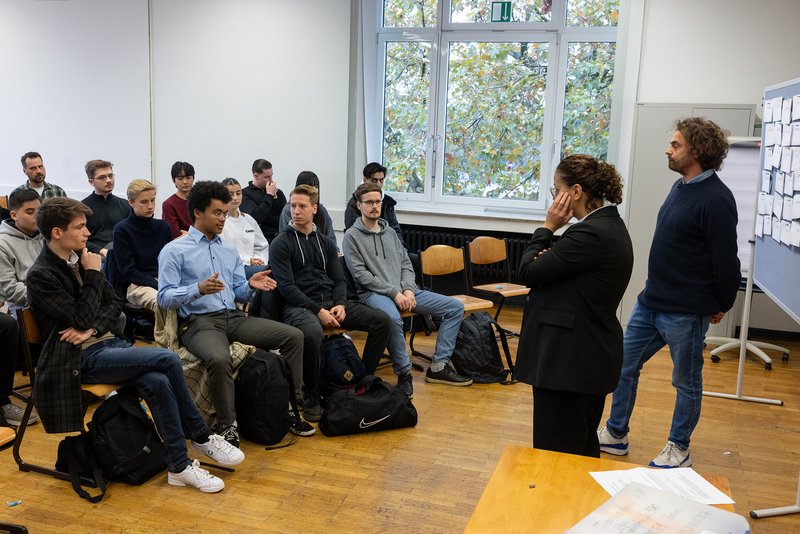 Teilnehmer*innen des Trialogs im Erich-Brost-Berufskolleg teilen ihre Gedanken mit den Pat*innen Jouanna Hassoun und Shai Hoffmann