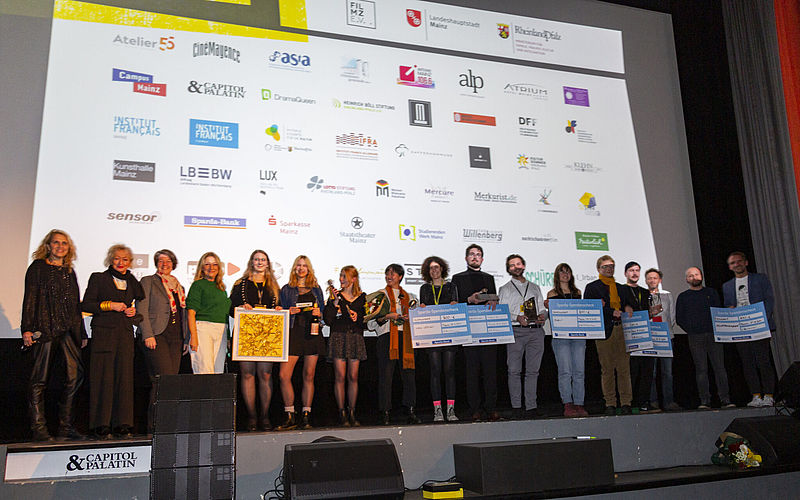 Die Gewinner:innen der Wettbewerbe von FILMZ - Festival des Deutschen Kinos bei der Preisverleihung auf der Bühne