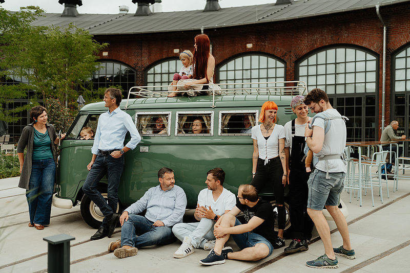 Menschen warten vor einem alten VW Bus