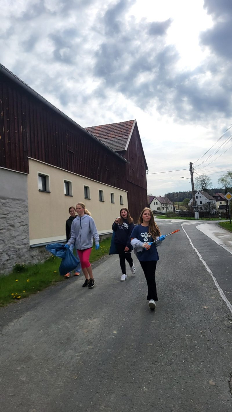 Kinder und Jugendliche sammeln gemeinsam Müll und engagieren sich für ihre Gemeinde.