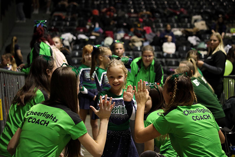 junge Coaches geben einer Sportlerin ein High-Five