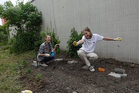 Zwei Helferinnen bepflanzen das Kartoffelbeet