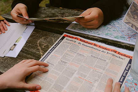 Teilnehmende schauen sich geschmuggelte Flugschriften an