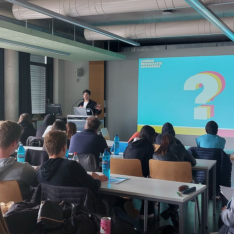 Der Katalog mit den Forderungen aus der Jugenddemokratiekonferenz wird an Politiker*innen übergeben