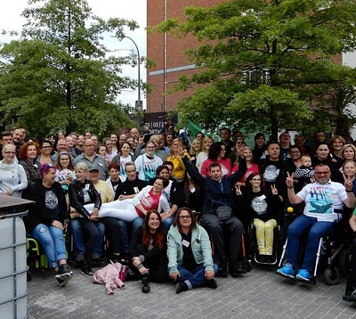 Eine große Gruppe von Menschen, einschließlich derer im Rollstuhl. Mitglieder der F.U.MS.