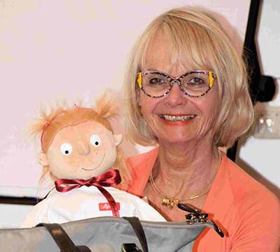  Lächelnde Frau hält Puppe im Arm 