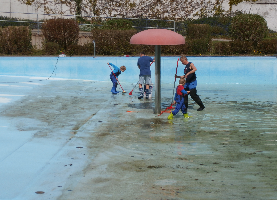 Kinder und Erwachsene reinigen gemeinsam ein Schwimmbecken